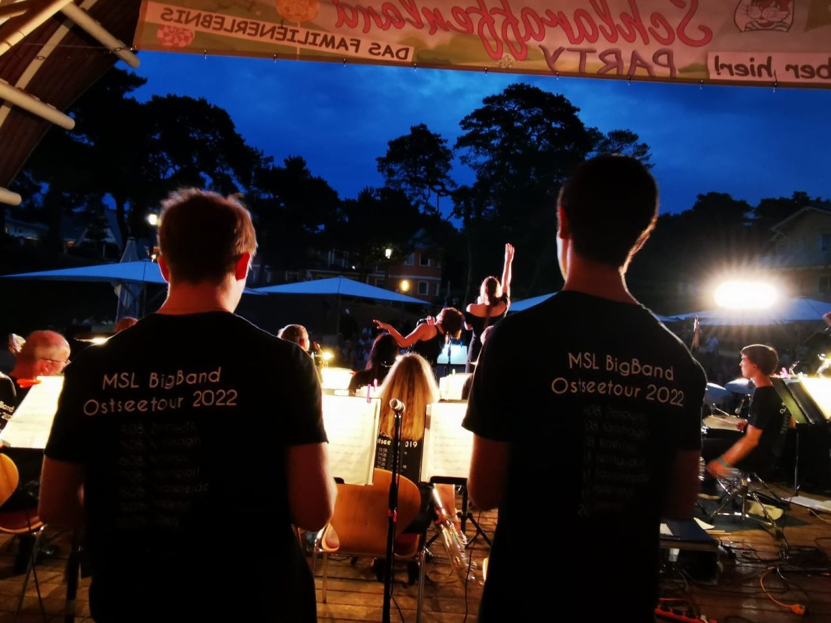 Blick von der Bühne hinter der Band auf das Publikum, abends